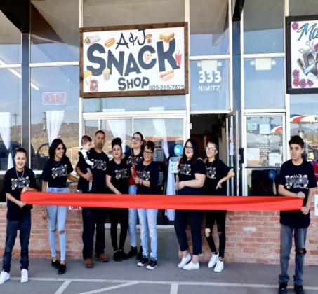 A&J Snack Shop owner Anna Olveda cuts the ribbon at the Grand Opening Celebration for her business, standing alongside family and friends and that helped her make it happen. Kylie Garcia - CC