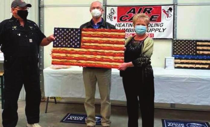 Craig Chapman, left, and Dawn Chapman, far right, present the “Rustic American” flag to hospital CEO Thomas Whelan at the Feb. 16 ceremony. Courtesy photo