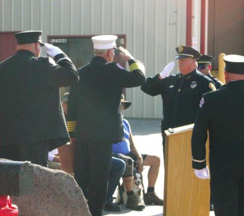 Grants Police Chief, Steve Chavez (right) salutes Grants Fire &amp;amp; Rescue Chief Robert Hays following a plaquard GPD gave to Grants Fire &amp;amp; Rescue. Scott Ford - CC