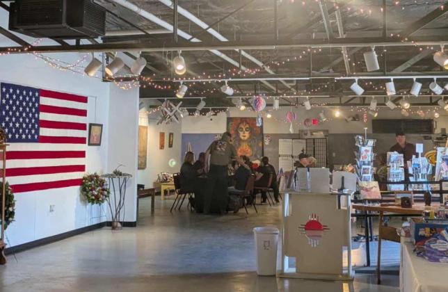 Veterans and community members gather for a Veterans Day lunch at the Double Six Art Gallery in Grants, surrounded by patriotic displays and floral arrangements created by Grants FFA students.