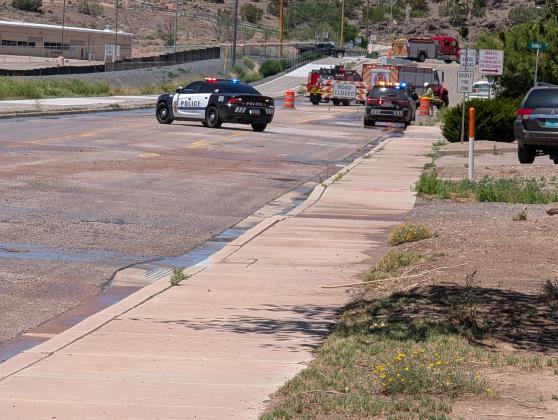 Emergency crews block off Roosevelt Avenue near Grants High School on Saturday after a roadway collapse left a 2023 Dodge lodged in what officials described as a sinkhole. No injuries were reported, and the cause of the collapse remains under investigation.