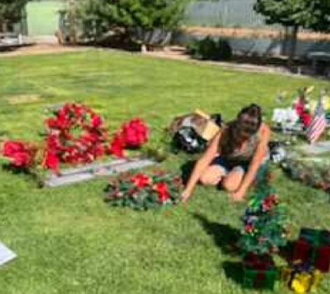 A woman decorates a loved ones gravesite on Friday, July 29.In addition to Memorial Park being decorated with ornaments by Mayor Erik Garcia and City employees, many people decorated their loved ones gravesites for the Christmas in July event. Courtesy Photo