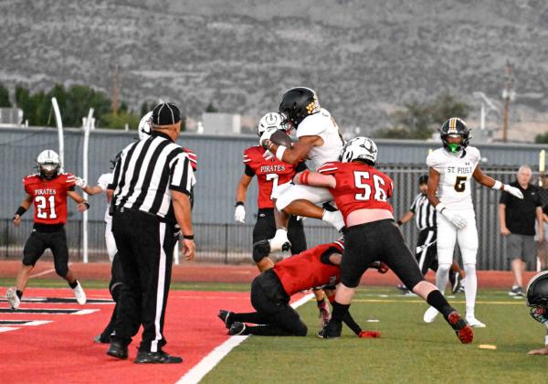 Grants High School Quarterback Tristin Fernandez, 5, with a hand off to senior running back Joe Clawson, 23, this past Friday at a home game against the St. Pius Sartans (2-0). The Pirates had a great first half, however, St. Pius left with the win, 34-20. Franklin Romero - CC