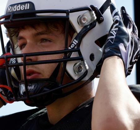Senior Brayden Cumper adjusts his helmet as he prepares for another drill during football practice on Aug. 10 at Grants High School in Grants, N.M. Jay Langford- Student Journalist