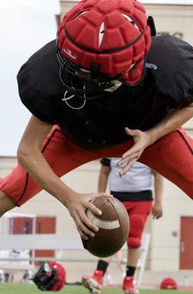 Sophomore Gabriel Graham prepares to snap the football during a drill on Aug. 10 at Grants High School in Grants, N.M. Jay Langford-Student Journalist