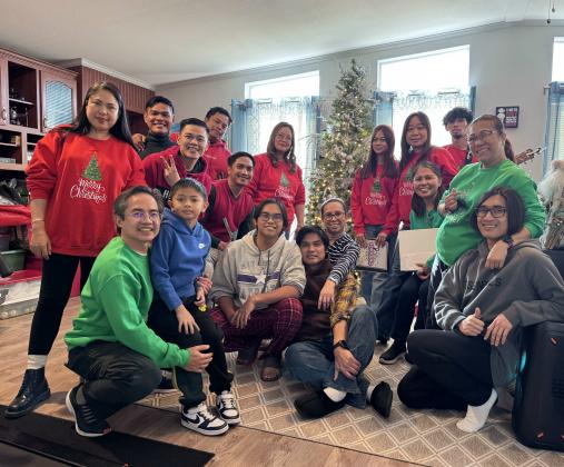 Mr. Garland and Mrs. Siela Rivera welcome carolers with warm smiles and Christmas colors. PHOTO – Courtesy