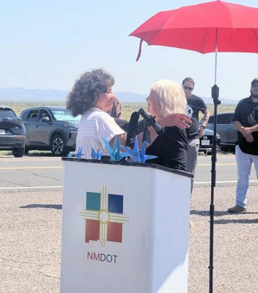 Tina Cordova, left, co-founder of Tularosa Basin Downwinders Consortium, embraces state Rep. Joanne Ferrary, D-Las Cruces, during a sign unveiling on July 16, 2025, to honor nuclear testing downwinders. Ferrary spoke at length during the event, which also celebrated the passing of a renewed and expanded Radiation Exposure Compensation Act on July 3. Courtesy Photo