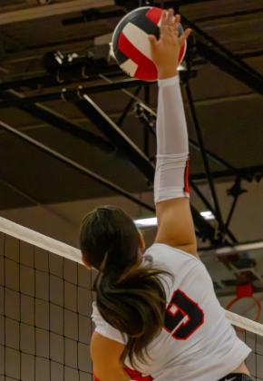 Bianca Murillo, senior, reaches high above the net to attack the ball during play. Photo by Jay Langford
