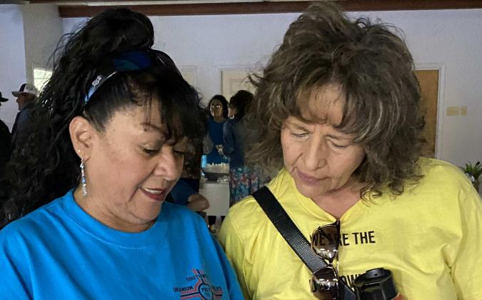Loretta Anderson of Southwest Uranium Miners Post '71 Coalition and Tina Cordova of Tularosa Basin Downwinders Consortium go over the agenda at a May meeting in Cubero, N.M., where Cordova spoke about RECA coverage for downwinders. Photo by Kathy Helms