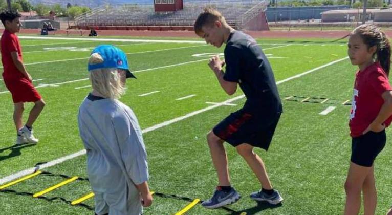 Larry Meador, a junior on the Grants Pirates football team demonstrates a drill to area youth as part of the Ty Detmer DYFL All-Star Camp. The threeday camp was held over the weekend. Franklin Romero - CC