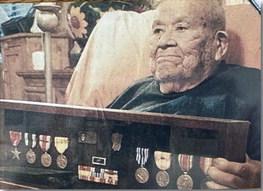 Sam Antonio, photographed late in life, holds the medals he earned during World War II. Among them is the Bronze Star, awarded for heroic or meritorious service. Despite enduring brutal captivity and forced labor, Antonio never received the Purple Heart — an honor his family continues to fight for today. Courtesy Photo