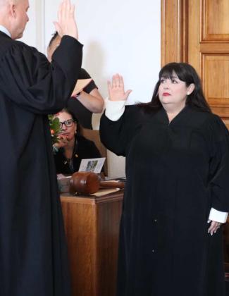 Chief Justice Julie J. Vargas takes the oath of office from Justice David K. Thomson, her predecessor as Chief Justice. Courtesy Photos