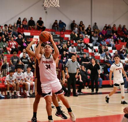 Dominick Gonzales (34) battles in the paint and puts up a shot during a dramatic district tournament matchup against the Belen Eagles. The game stretched into double overtime before Belen edged out a 71–63 win. The Pirates showed grit and heart, closing out their season with one of their most intense performances of the year. Franklin Romero - CC