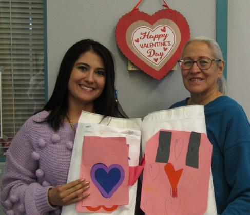 Mt. Taylor Elementary Principal Amanda Valdez (L) presents Evelyn Siegmann with Valentine's crafted by her school's students for this year's 'Sharing Hearts and Touching Lives' program. Photo by Roger Siegmann