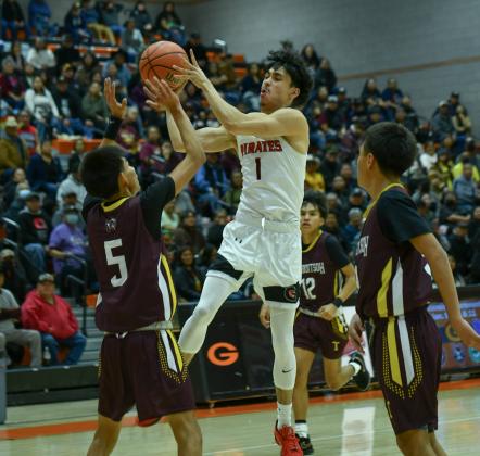 The Grants High School boys’ Pirates basketball team went 2-1 at the Gallup Invite last week and forced an overtime with the third ranked team in 4A, the Hope Huskies at home. The Pirates tied it up 58-58 after trailing by as much as 12 points – however, the Pirates came up short 68-63. In this photo Roberto 'Beto' Chavez, 1, leaps in the air to find an open teammate in a close game against Tohatchi at the Gallup Invite.