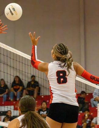Sophomore Kiana Guzman attacks the ball over an opposing blocker during a recent volleyball match at Grants High School. Jay Langford- Student Journalist