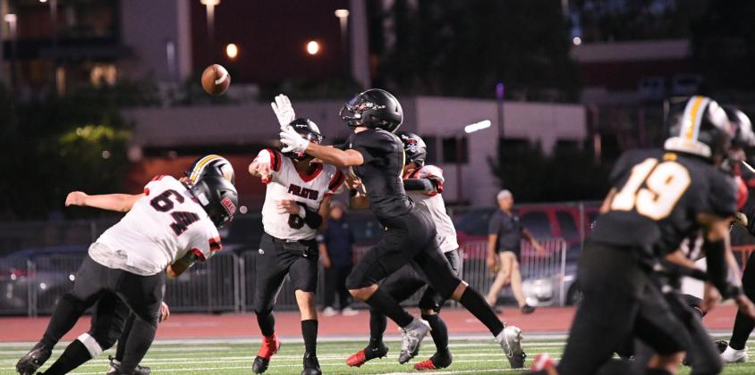 Quarterback DJ Chavez,8, throws under pressure this past week at Mile Stadium as the Pirates faced their former district rival, the St Pius Sartans. The Sartans won the contest 40-7. Franklin Romero - CC
