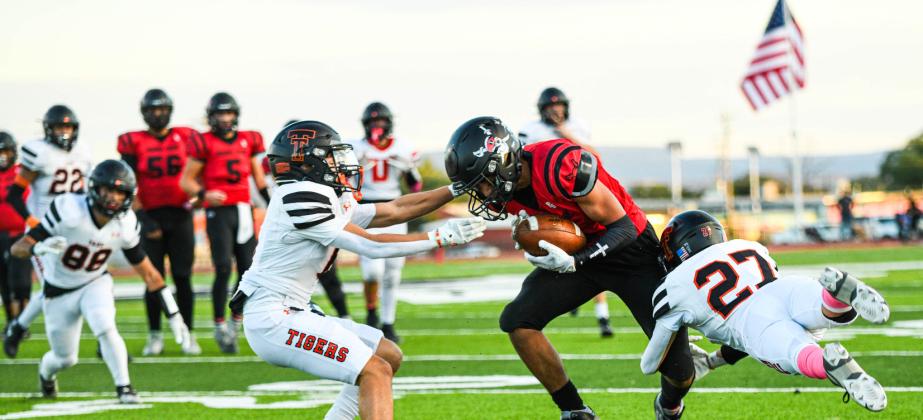 Cardenio Chavez, 2, fights off two defenders after a successful catch against the Taos Tigers last Friday at the Port of the Pirates. The Pirates defeated the ranked Tigers in a hard fought game by a score of 21-19. Franklin Romero - CC