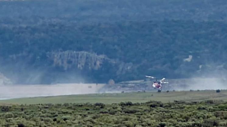 A helicopter dips into water from Bluewater Lake on Aug. 10 to assist firefighting efforts on the Four Mile Fire in the Zuni Mountains near Jamestown. Photo by Kathy Helms
