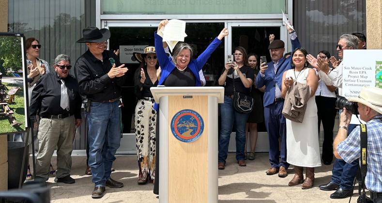 New Mexico Land Commissioner Stephanie Garcia Richard raises the signed Executive Order 2026-002 after formally prohibiting new uranium mining leases on state trust lands. Supporters gathered outside the State Land Office applauded the action, which does not prohibit uranium development on federal, private or Tribal lands and does not affect valid existing mineral rights. Courtesy Photo
