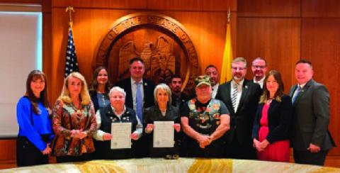 Surrounded by lawmakers, veterans, and advocates, Governor Michelle Lujan Grisham holds signed copies of House Bill 47 and House Bill 161, expanding property tax exemptions and granting free state park access to veterans. The new laws, signed on March 20, 2025, mark a significant step in honoring New Mexico’s veterans and were championed in part by the late Rep. Eliseo “Lee” Alcon. Courtesy Photo