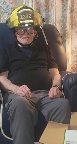 Retired firefighter Ed Miles proudly wears the Milan Fire Department helmet that MFD gifted to him for his 25 years of service to the department, as well as for his 97th birthday. Courtesy Photo — Milan Fire Department