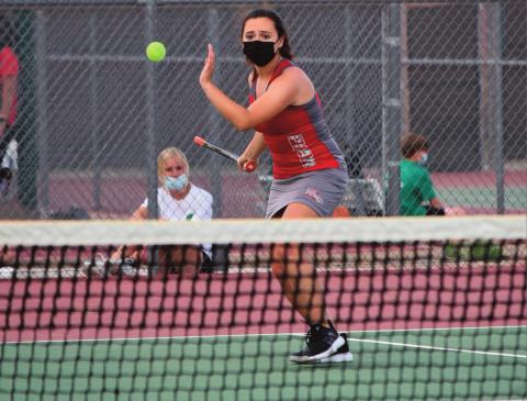 Kylette Garcia (top photo), current number two2, on the GHS girls tennis team focuses on the incoming ball at a recent home match. The lady Pirates are 7-2,5-1. A lady Pirate softball player (below) fields a ball while keeing ther opponet on the base. Courtesy photos