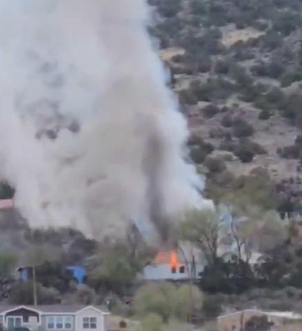 Flames and thick smoke rise from a structure fire on Haystack Place early Monday morning. Firefighters from Milan, Grants, and Cibola County rushed to the scene and knocked down the blaze before it could spread further Photo By Eric Brinn