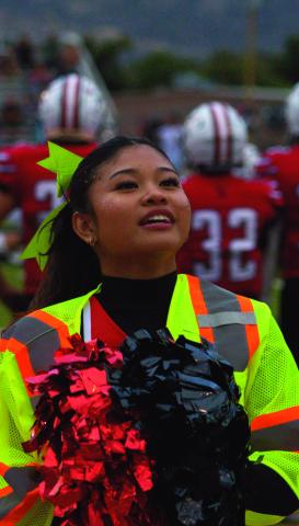 Jay Langford- Student Journalist Chloe Marquez, senior, raises a pom-pom while performing with the Grants High School cheer team on Sept. 11. Marquez cheers from atop a stunt as the team supports the Pirates during the home football game