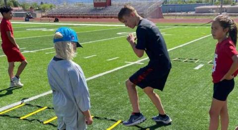Larry Meador, a junior on the Grants Pirates football team demonstrates a drill to area youth as part of the Ty Detmer DYFL All-Star Camp. The threeday camp was held over the weekend. Franklin Romero - CC