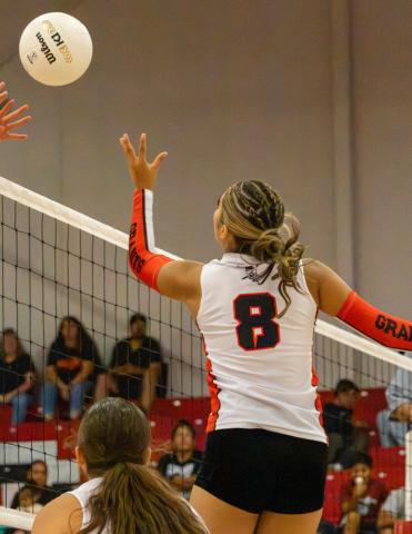 Sophomore Kiana Guzman attacks the ball over an opposing blocker during a recent volleyball match at Grants High School. Jay Langford- Student Journalist