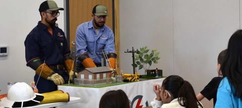 Continental Divide line workers Julien Martinez (left) and Bob McKinnon demonstrate the co-op’s new Power Town for Mount Taylor Elementary School’s secondgrade class. Courtesy Photo
