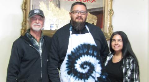 Santiago Chavez (c) and wife Denise are the winners of Tie Dye apron donated by Ian Smith from Double 6 Gallery Photo by Roger Siegmann