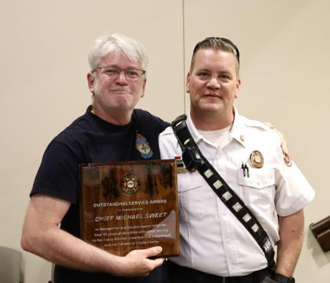 New Candy Kitchen Fire Department Chief John Sweet (left) accepts two Outstanding Service Awards on behalf of his parents, Chief Michael Sweet and Executive Assistant/Fire Fighter Shirley Sweet, who are retiring after 10 years of service to the dept. Cibola County Emergency Manager Dustin Middleton (right) presented the awards. Kylie Garcia - CC